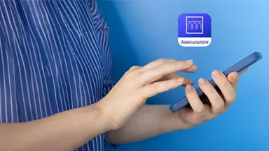 Mani di uomo che interagiscono con uno smartphone e visualizzazione icona app Intesa Sanpaolo Assicurazioni