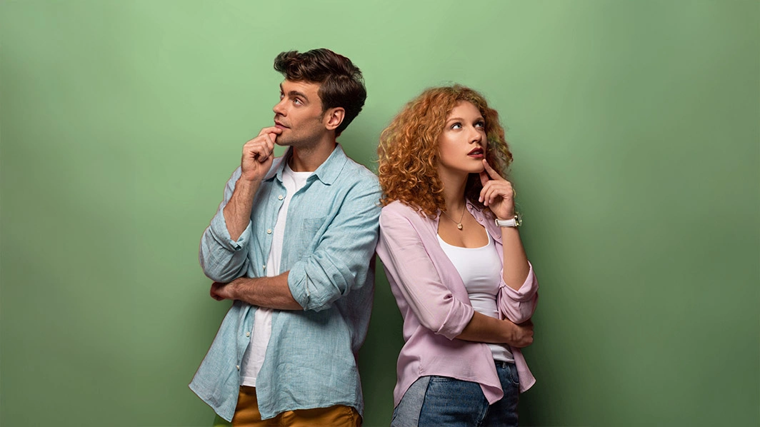 Ragazzo e ragazza pensierosi con dito sul mento e appoggiati uno alla spalla dell'altra