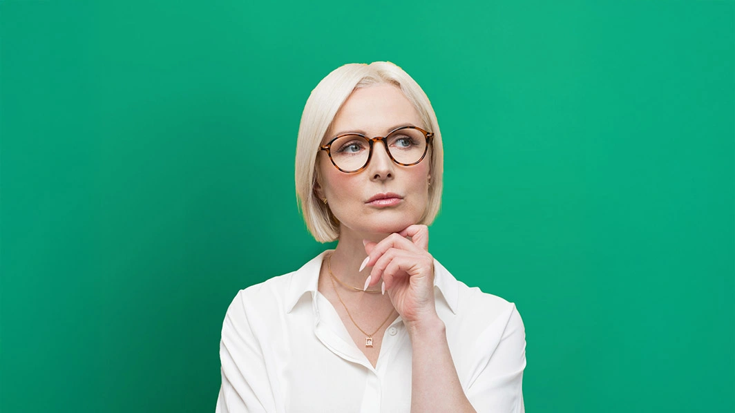 Donna pensierosa con dito appoggiato sotto al mento