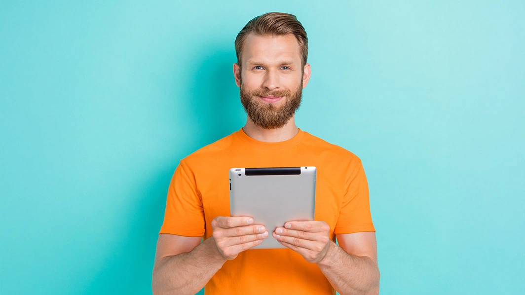 Uomo sorridente con in mano un tablet 